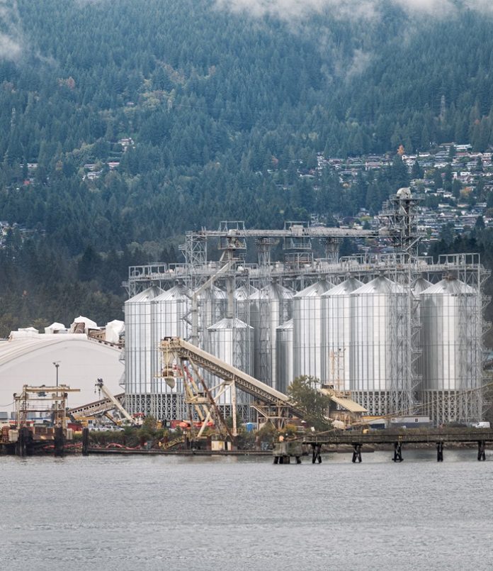 Oil refinery plant with tank and cargo ship at port in Vancouver sea